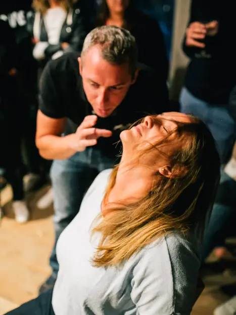 Pavlof l'hypnotiseur de spectacle hypnotisant une femme assise, offrant une expérience immersive.